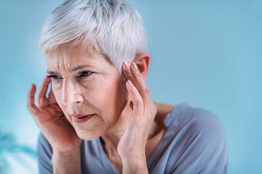 Woman experiencing tinnitus symptoms